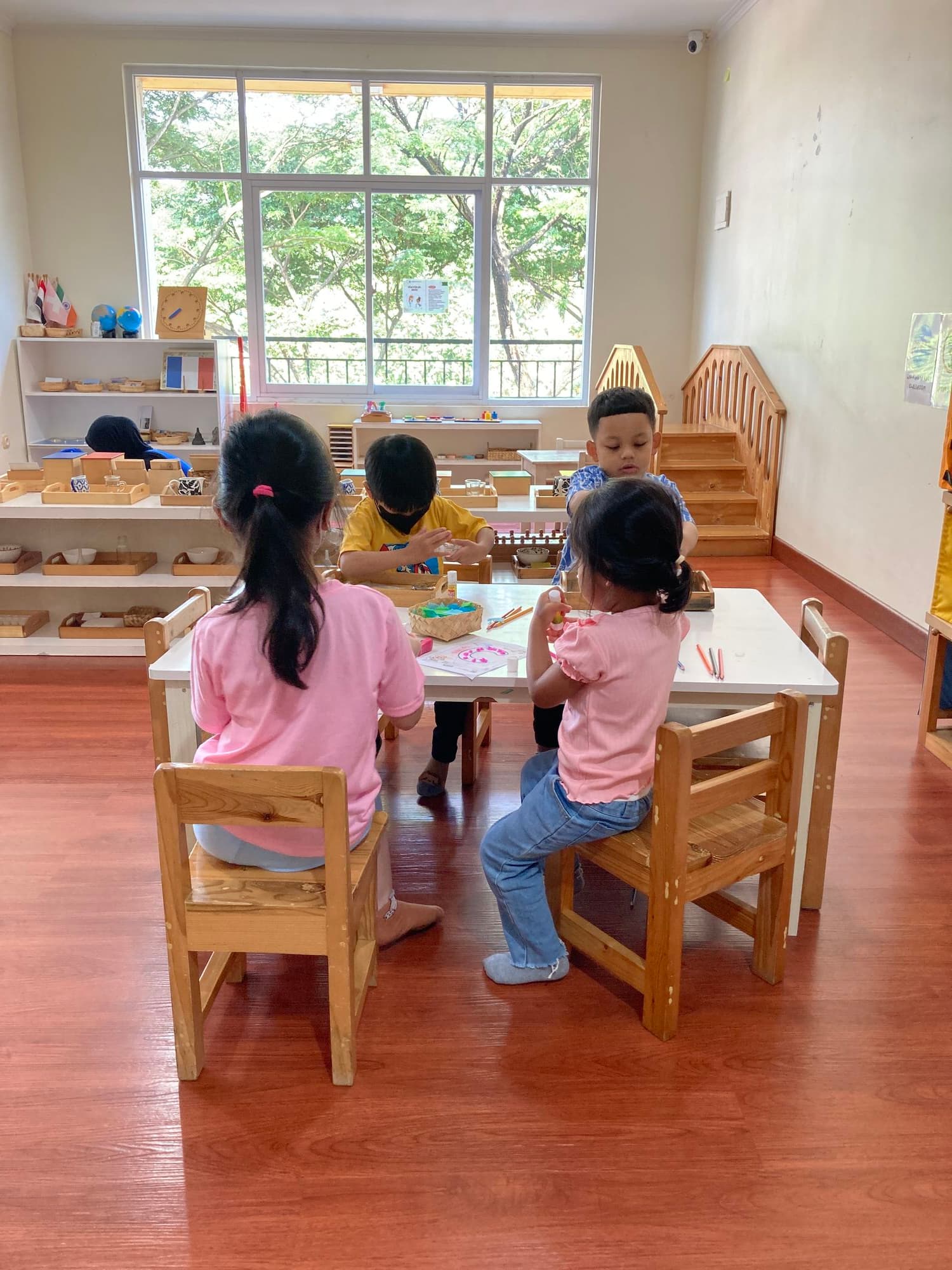 Bright Montessori classroom with child-sized wooden tables and natural light
