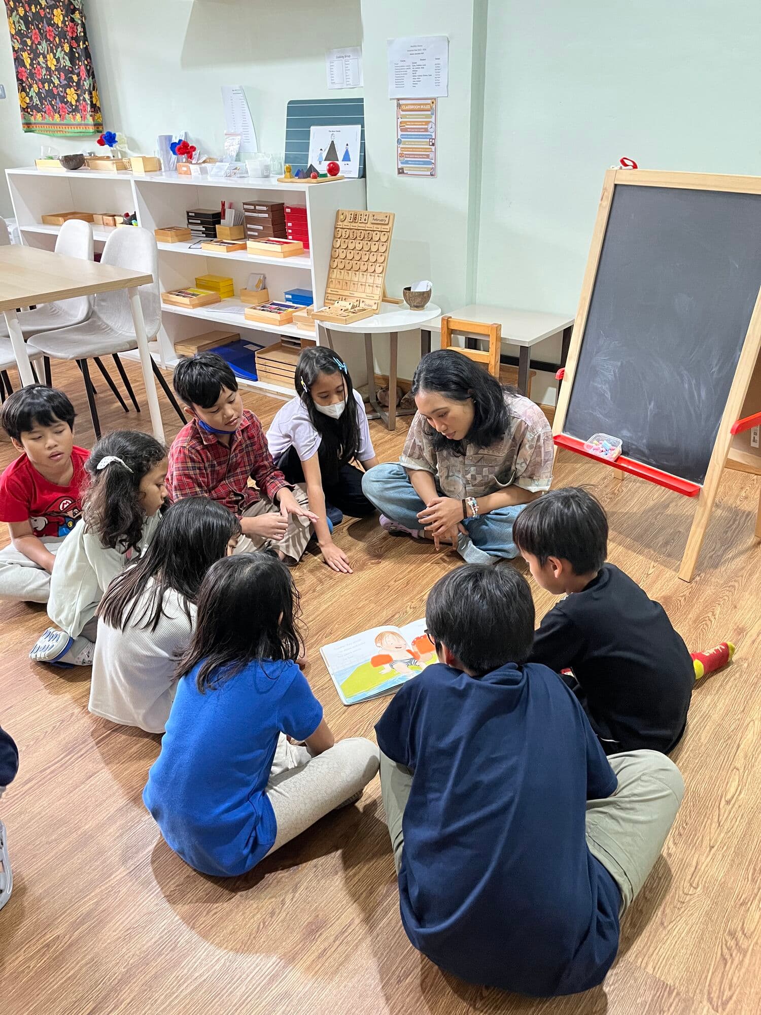 Guide reading a picture book to a group of children seated in a circle