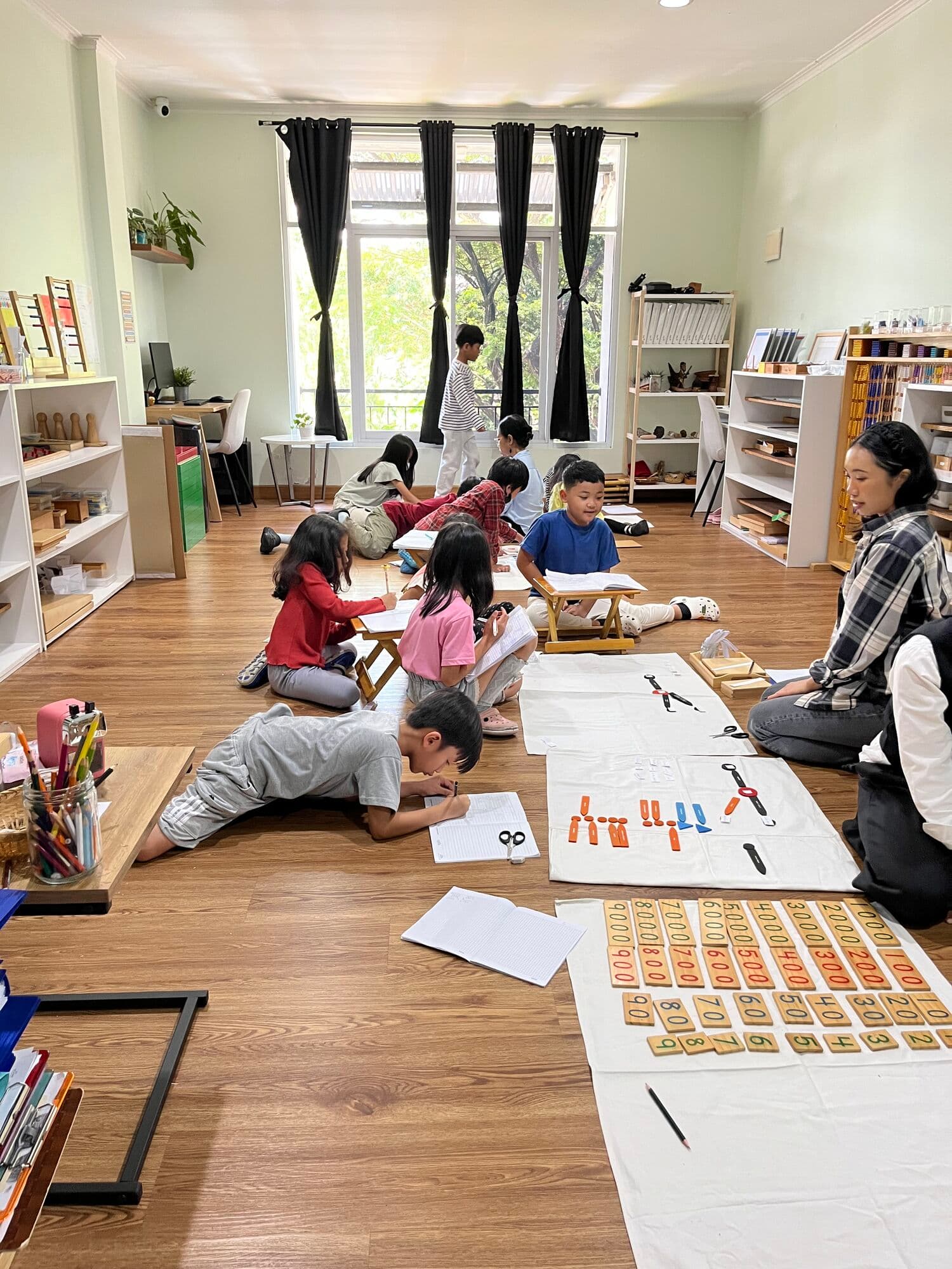 Children working together on art and writing projects on the classroom floor